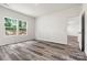 Bright bedroom featuring luxury vinyl plank floors, white walls, and double hung windows with wooded views at 3567 Farmfield Dr, Claremont, NC 28610