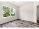 A sunny bedroom with wood-look flooring, large double windows, and neutral decor at 3567 Farmfield Dr, Claremont, NC 28610