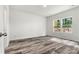 Bedroom with neutral walls, wood-look floors and a view of the landscaped backyard at 3567 Farmfield Dr, Claremont, NC 28610