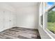 Bright bedroom featuring wood-look flooring, double door closet, and a large window with outside views at 3567 Farmfield Dr, Claremont, NC 28610