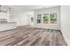 Bright living room with wood-look flooring and large windows overlooking the landscaped backyard at 3567 Farmfield Dr, Claremont, NC 28610