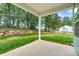 Covered patio looking out to a large backyard with a stone retaining wall at 3567 Farmfield Dr, Claremont, NC 28610