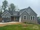 Charming home featuring gray vertical siding, brick accents, and a well-manicured lawn at 3733 Whitney Ne Dr, Hickory, NC 28601