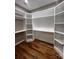 Large walk-in closet with custom white shelving and hardwood floors at 3733 Whitney Ne Dr, Hickory, NC 28601