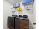 Laundry room featuring front-load washer and dryer with wire shelves, offering convenient storage solutions at 3748 Tea Olive Rd, Gastonia, NC 28056