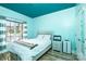 Comfortable bedroom with a large window for natural light and soothing turquoise color on the walls and ceiling at 3837 1St Street Nw Ln, Hickory, NC 28601