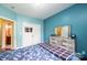 Bright bedroom with blue walls, a double-door closet, and light-colored wood floors next to the bathroom at 3837 1St Street Nw Ln, Hickory, NC 28601
