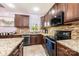 Well-lit kitchen featuring tile floors, stainless steel appliances, and granite countertops at 3837 1St Street Nw Ln, Hickory, NC 28601