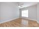 This airy bedroom features a ceiling fan, large window with blinds, and beautiful hardwood flooring at 400 N Church St # 413, Charlotte, NC 28202