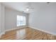 This bedroom features beautiful hardwood floors, a ceiling fan, and a window providing natural light at 400 N Church St # 413, Charlotte, NC 28202