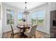 Bright dining area with a round table, four upholstered chairs, and view from the window at 4002 Tundra Rd, Charlotte, NC 28203