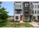 Modern townhome featuring multi-tone facade, manicured lawn, and a pop of color with a red front door at 4002 Tundra Rd, Charlotte, NC 28203
