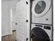 Efficient laundry area with stacked washer and dryer, along with a white door at 4002 Tundra Rd, Charlotte, NC 28203