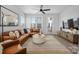 Cozy living room with a leather sectional, a round coffee table, and large windows for natural light at 4002 Tundra Rd, Charlotte, NC 28203