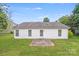 Backyard view featuring a well-maintained lawn, white siding and a small patio at 4227 Coopersdale Rd, Charlotte, NC 28273