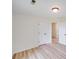 A bedroom with neutral walls, light wood flooring, and doorway to the bathroom at 4227 Coopersdale Rd, Charlotte, NC 28273