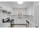 Updated kitchen featuring white cabinetry, subway tile backsplash, stainless steel appliances, and tile flooring at 4227 Coopersdale Rd, Charlotte, NC 28273