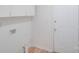 Bright laundry room with overhead cabinets and a white door at 4227 Coopersdale Rd, Charlotte, NC 28273