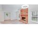 Cozy living room with brick fireplace, light wood flooring, and natural light at 4227 Coopersdale Rd, Charlotte, NC 28273
