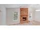 Spacious living room featuring a brick fireplace, hardwood floors, and large windows that allow in natural light at 4227 Coopersdale Rd, Charlotte, NC 28273