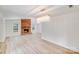 Open living room with brick fireplace, light wood flooring, and chandelier at 4227 Coopersdale Rd, Charlotte, NC 28273