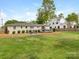 Spacious backyard featuring lush lawn, mature trees, an outdoor dining area, and a charming patio, perfect for entertaining at 4346 Walker Rd, Charlotte, NC 28211
