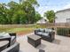 Backyard patio with outdoor seating, a cushioned sofa, a lush lawn, and mature trees at 4346 Walker Rd, Charlotte, NC 28211