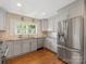Bright eat-in kitchen with stainless steel appliances, light gray cabinetry, and hardwood flooring at 4346 Walker Rd, Charlotte, NC 28211