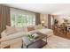 Bright living room with large windows, hardwood floors, and a comfortable sectional sofa at 4346 Walker Rd, Charlotte, NC 28211