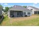 Back exterior view with a screened-in porch, grill, and well-maintained yard, ideal for outdoor enjoyment at 471 Lucky Nw Dr, Concord, NC 28027