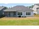 View of the home's backyard, featuring a screened-in porch, a grill, and a well-manicured lawn at 471 Lucky Nw Dr, Concord, NC 28027