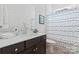 Bathroom featuring dark cabinets, white sink, and shower with blue wave curtain at 471 Lucky Nw Dr, Concord, NC 28027