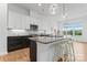 Modern kitchen featuring an island with barstool seating, white cabinets and stainless steel appliances at 471 Lucky Nw Dr, Concord, NC 28027