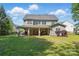 Spacious backyard featuring a covered patio, manicured lawn, and charming landscaping perfect for relaxation at 4853 Walnut Grove St, Harrisburg, NC 28075