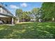 Expansive backyard with lush green lawn, mature trees, and a covered patio for outdoor living at 4853 Walnut Grove St, Harrisburg, NC 28075
