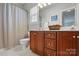 Bathroom with wood vanity, tiled floors, and a shower showcasing a modern design at 4853 Walnut Grove St, Harrisburg, NC 28075