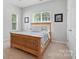 Comfortable bedroom with wooden bed frame, natural light from the windows, and neutral wall colors at 4853 Walnut Grove St, Harrisburg, NC 28075