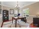 Bright office space featuring a wooden desk, a large window with natural light, and hardwood floors at 4853 Walnut Grove St, Harrisburg, NC 28075