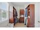 Spacious walk-in closet with custom wood shelving and ample storage; features a window for natural light at 4853 Walnut Grove St, Harrisburg, NC 28075