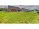 View of the spacious, grassy backyard with a patio, enclosed by a sleek black fence, perfect for outdoor activities at 4926 Trayton Ave, Gastonia, NC 28056