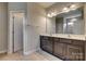 A bathroom featuring double sinks, dark cabinets, and a large mirror providing style and functionality at 4926 Trayton Ave, Gastonia, NC 28056