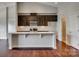 Kitchen featuring a large island, granite countertops, and dark wood cabinetry at 4926 Trayton Ave, Gastonia, NC 28056