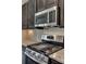 Close-up of kitchen stainless gas cooktop, microwave and dark cabinetry at 4926 Trayton Ave, Gastonia, NC 28056