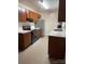 A bright kitchen with wooden cabinets, marble countertops, a stainless steel refrigerator, and modern appliances at 522 Pennsylvania Ave, Charlotte, NC 28216