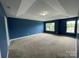 Spacious bedroom with tray ceilings, large windows, and neutral carpet at 5619 Fenway Dr, Charlotte, NC 28273