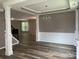 Open dining room featuring decorative columns, wainscoting, stylish chandelier, and wood-look flooring at 5619 Fenway Dr, Charlotte, NC 28273