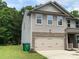 Charming home exterior featuring gray siding, stone accents, and an attached two-car garage at 5619 Fenway Dr, Charlotte, NC 28273