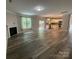 Open-concept living room with hardwood floors, fireplace, and kitchen with island at 5619 Fenway Dr, Charlotte, NC 28273