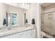 Bright bathroom with dual sinks, granite countertop, and glass-enclosed shower at 5712 Runnel Way, Charlotte, NC 28215