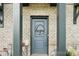 Close up of the front door with brick facade and decorative Gambrell monogram at 5712 Runnel Way, Charlotte, NC 28215